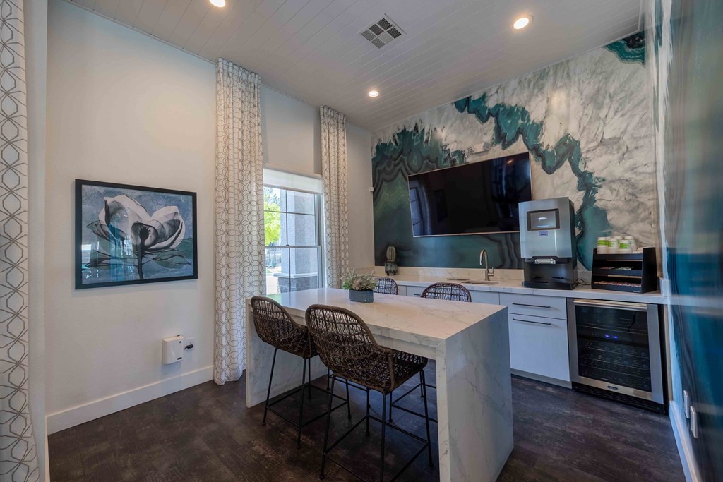 a kitchen with a counter and chairs and a tv