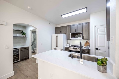 a kitchen with a large white counter top and a sink