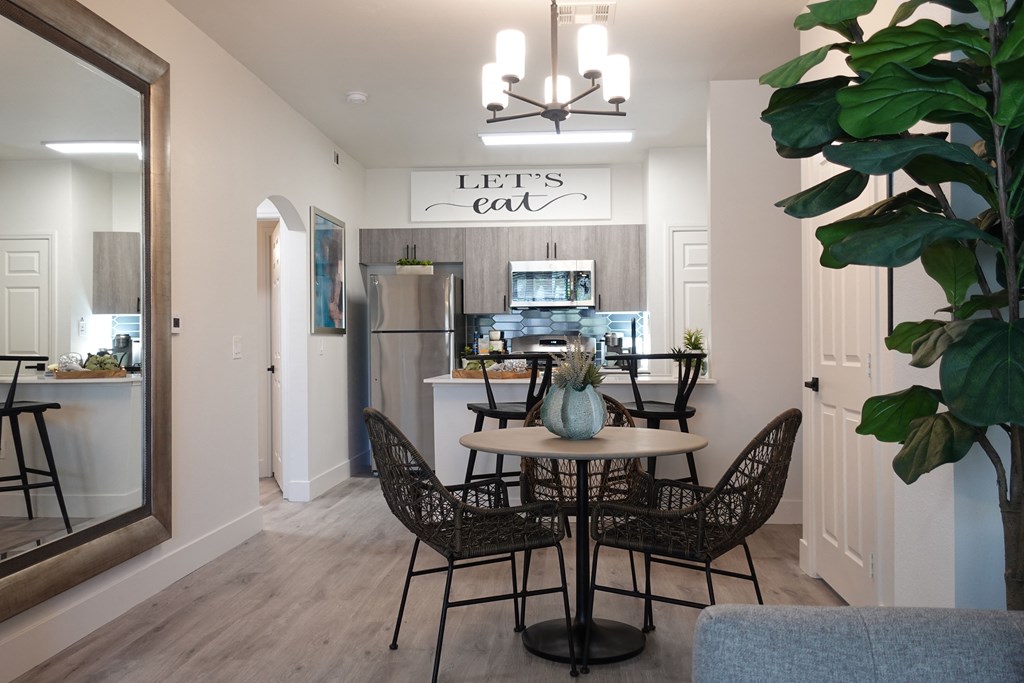 a dining room and kitchen with a table and chairs