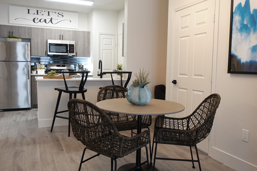 a dining room with a table and chairs and a kitchen