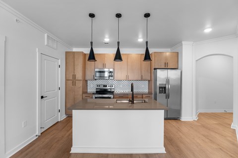 A kitchen with a white counter and wooden cabinets.