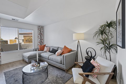 a living room with couches and a table and a large window
