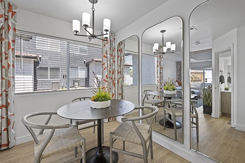a dining area with a table and chairs and a large window