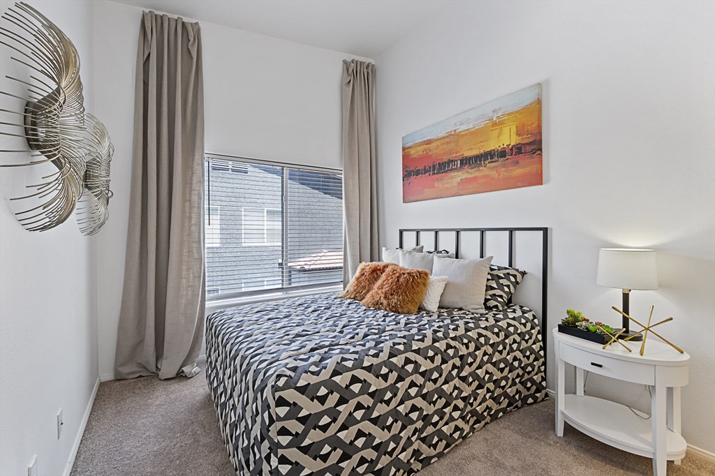 a bedroom with a bed and a large window