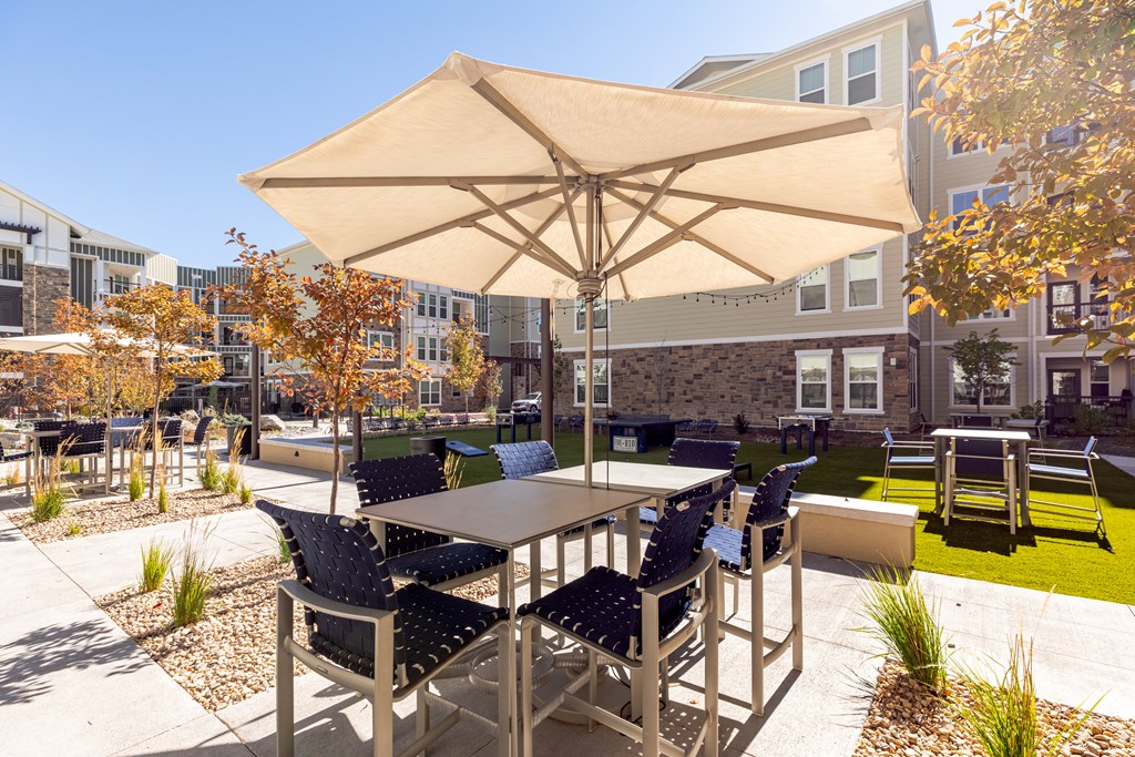 an outdoor patio with tables and chairs and an umbrella