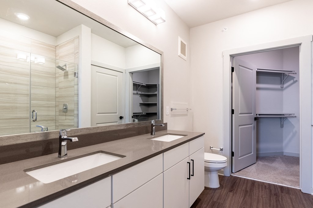 a bathroom with two sinks and a shower and a toilet