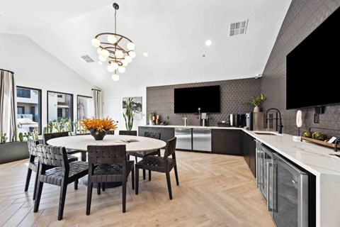 A modern kitchen with a dining table and chairs.