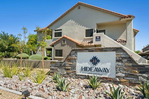 A house with a sign that says HIDEAWAY in front of it.