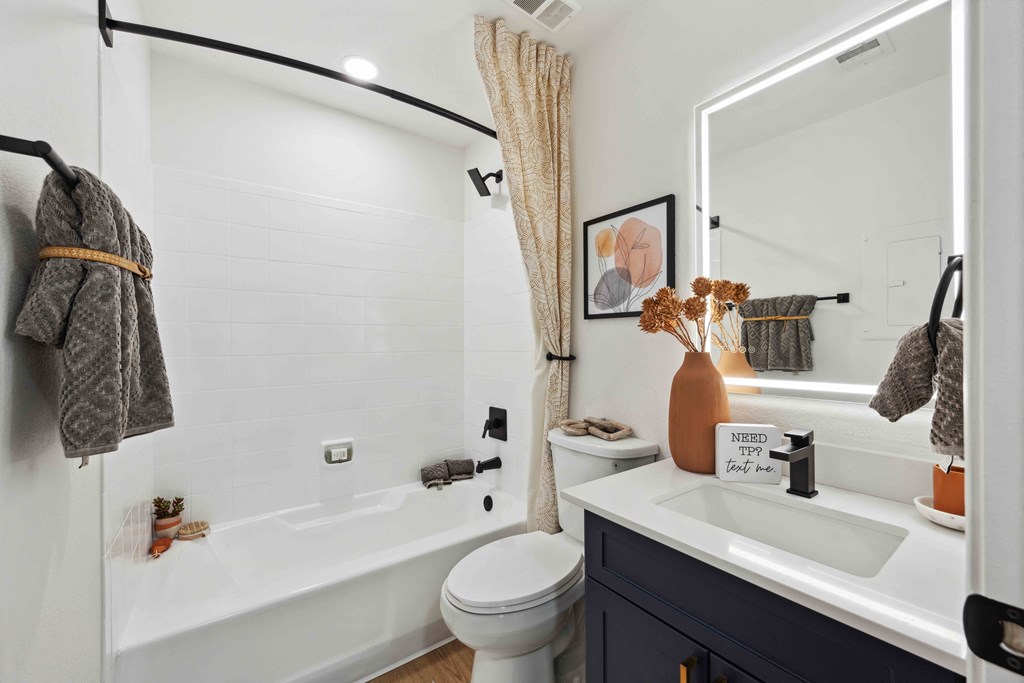 a bathroom with a white tub next to a toilet and a sink