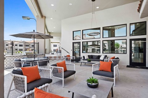 a patio with chairs and couches and a table with a potted plant