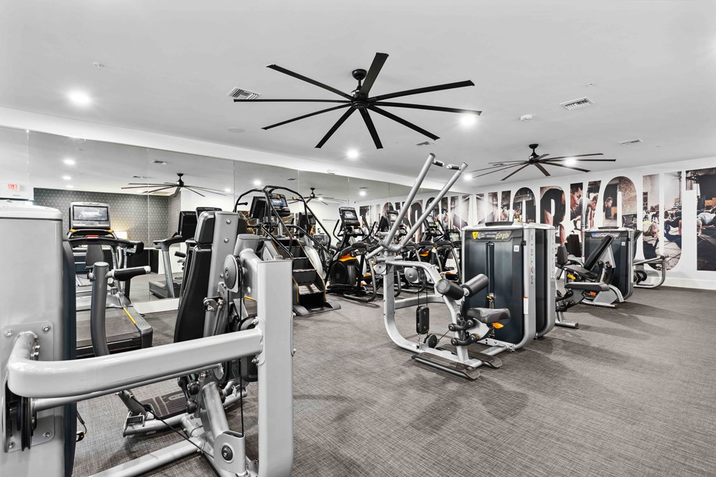 a large fitness room with cardio machines and other exercise equipment