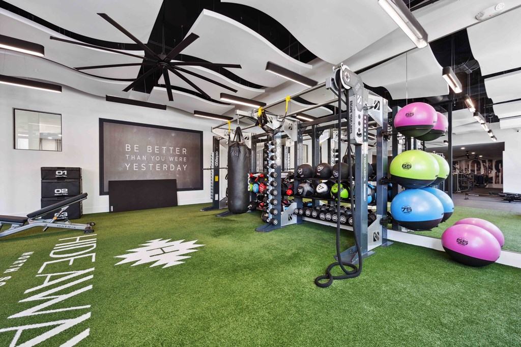 a spacious fitness room with green carpet at hideaway apartments