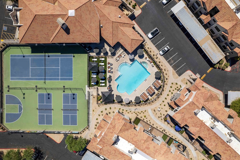 aerial view of hideaway apartments with a swimming pool and tennis court