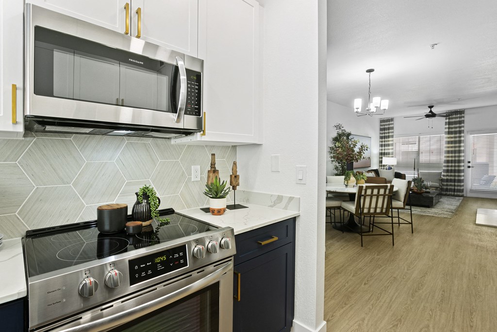 a kitchen and living room with a stove and a microwave