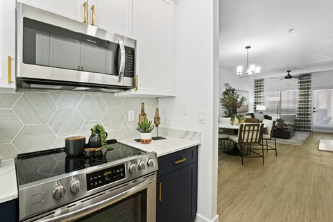a kitchen and living room with a stove and a microwave