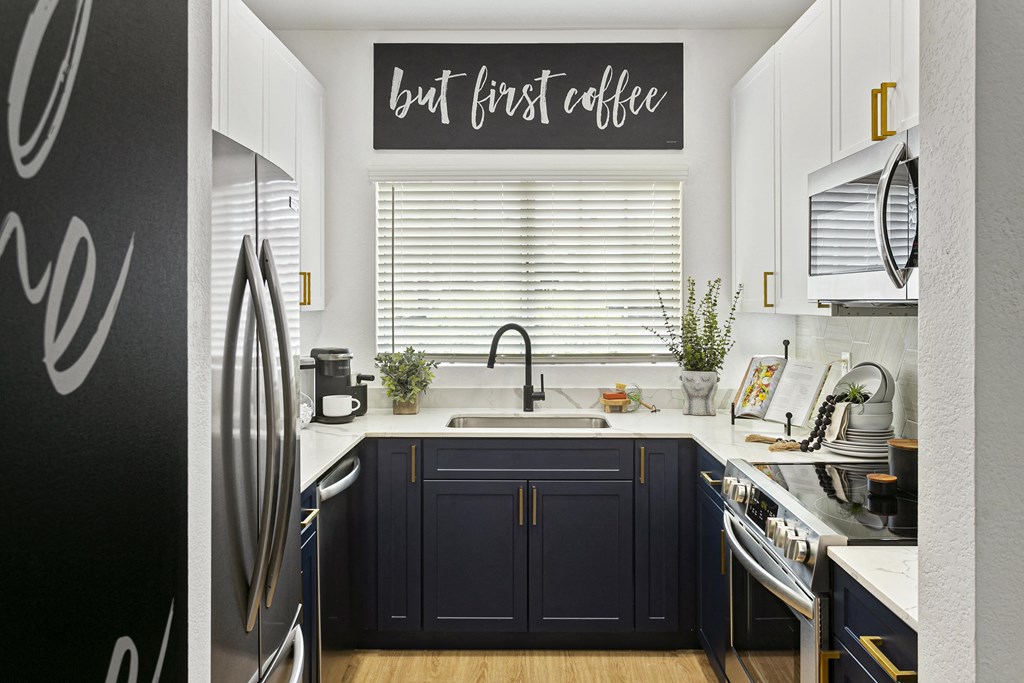 a kitchen with black cabinets and a sink and a window