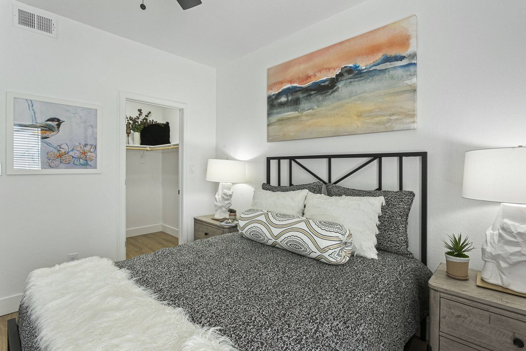 a bedroom with a bed and a painting on the wall