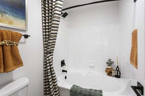 a white bathroom with a tub and a shower curtain