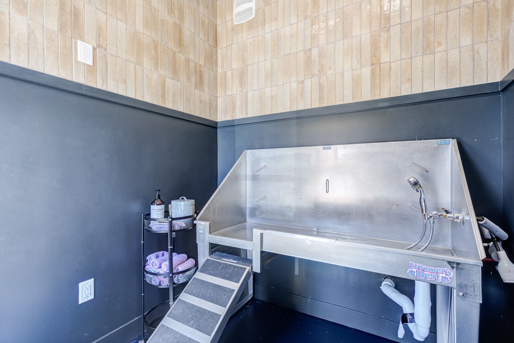 a small bathroom with a stainless steel sink and wooden walls