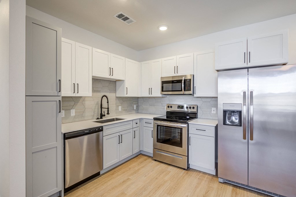 a kitchen with stainless steel appliances and white cabinets