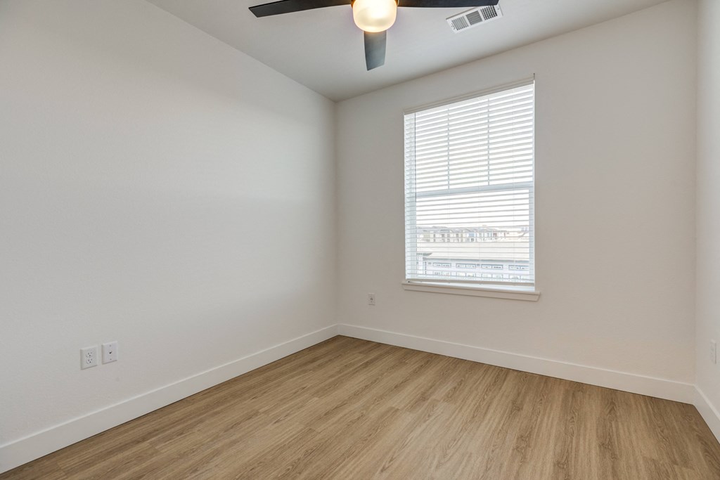 an empty room with wood floors and a window