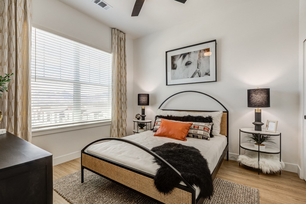an apartment bedroom with a bed and a large window