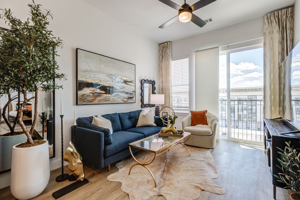 a living room with a blue couch and a ceiling fan