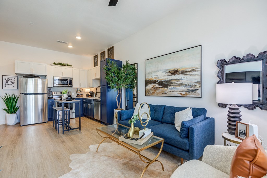 a living room with a couch and a coffee table and a kitchen