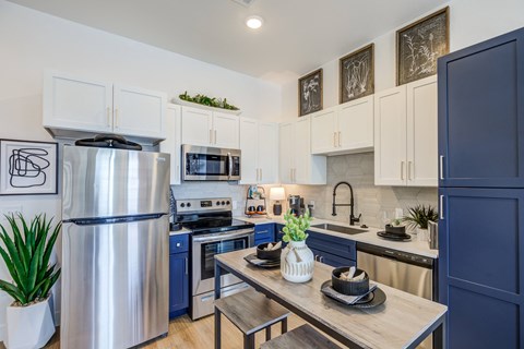 a kitchen with stainless steel appliances and a wooden table