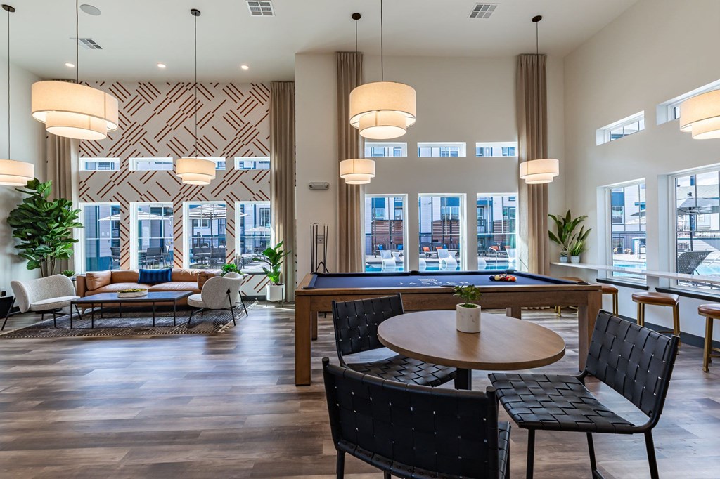 an open living room with a pool table and tables