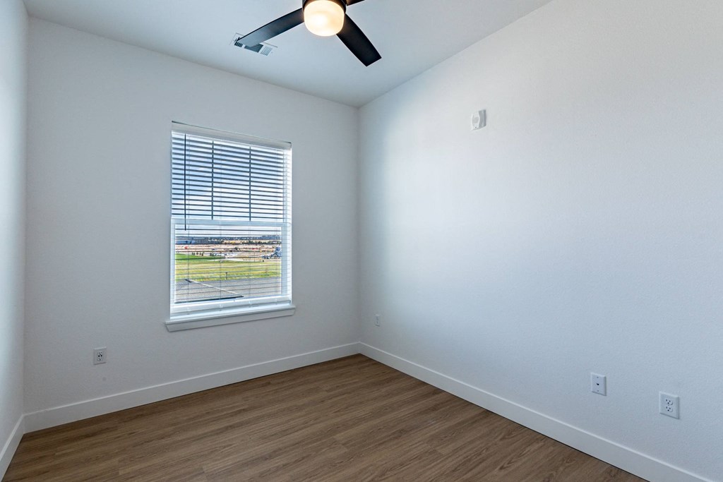 a large room with a window and a ceiling fan