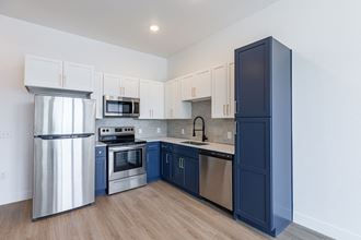 a kitchen with stainless steel appliances and blue and white cabinets