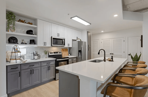 a kitchen with gray cabinets and white countertops