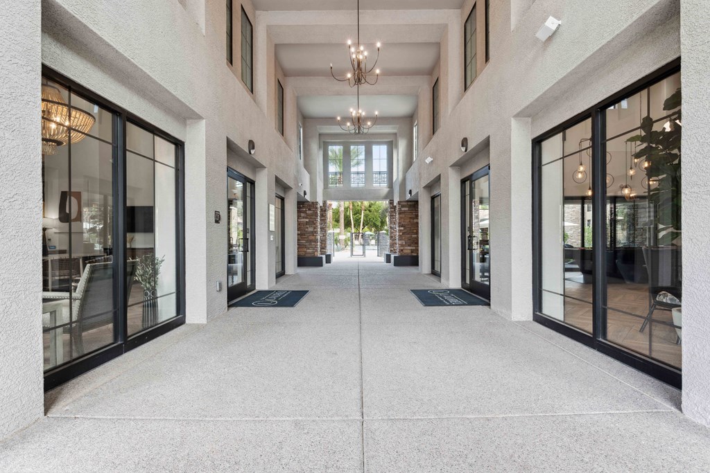 the lobby of a building with glass doors and a chandelier