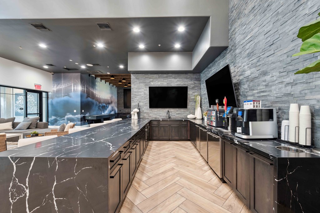 the lobby of a hotel with a kitchen and a tv
