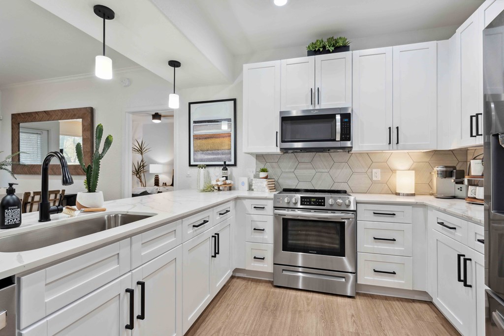 Bright kitchen with quartz countertops and stainless appliances found at The Laurel Apartments for rent Chandler Arizona.