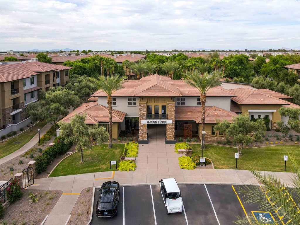 a building with palm trees in front of a parking lot