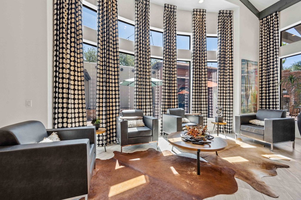 clubhouse at lazo apartments filled with furniture and a large window