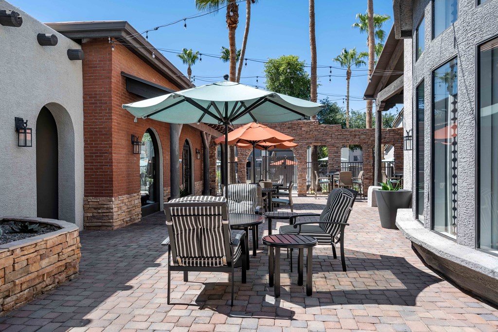 a patio with tables and umbrellas