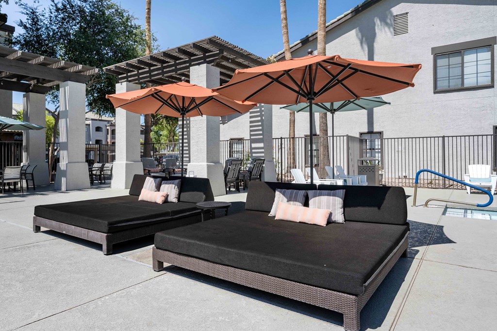 two couches with umbrellas in front of a building