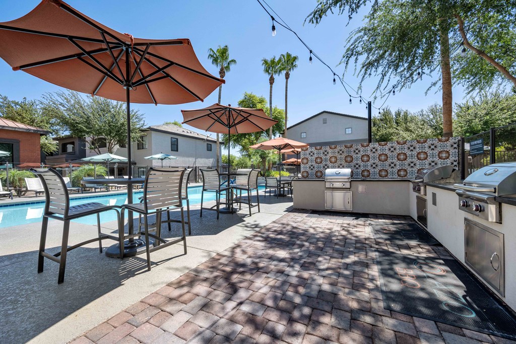 bbq grill area near swimming pool at lazo apartments in chandler, az