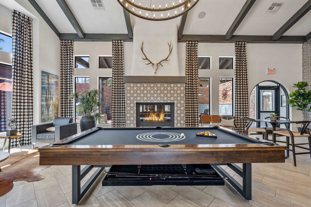 a pool table in the lobby of a building with a fireplace