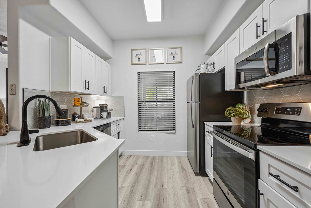 a kitchen with white cabinets and stainless steel appliances