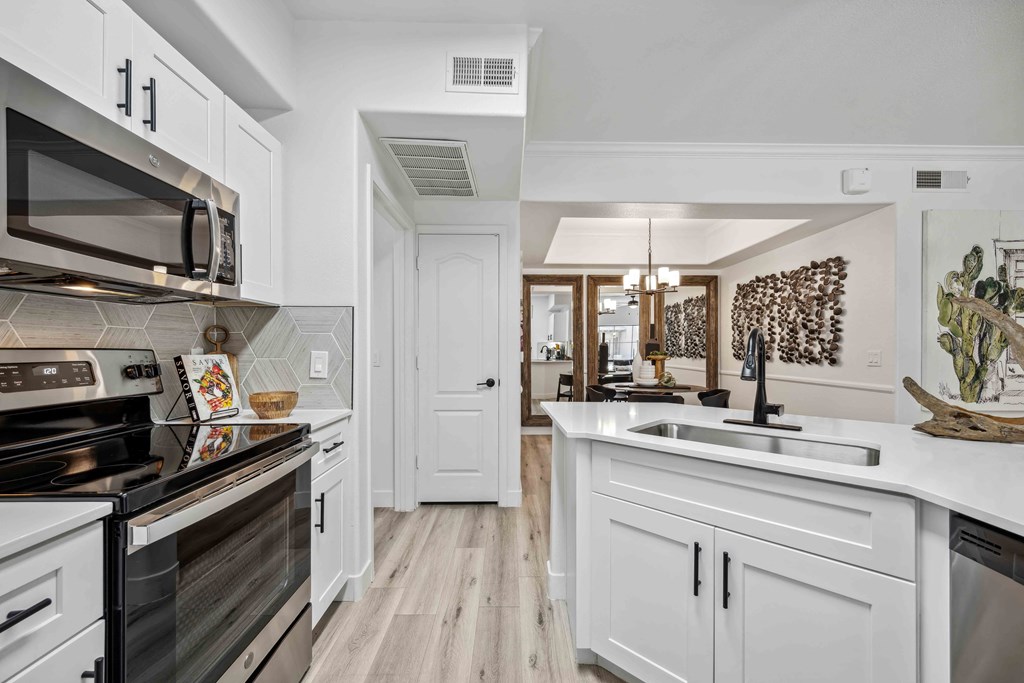 a kitchen with white cabinets and stainless steel appliances