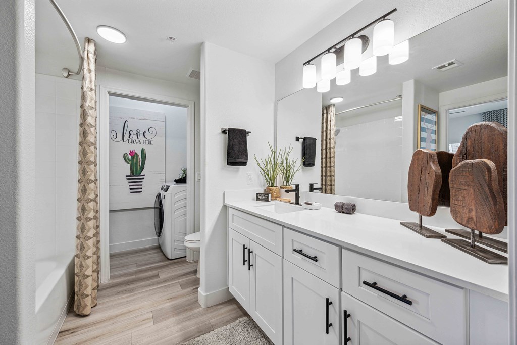 bathroom with white cabinets and roman garden tub at lazo apartments