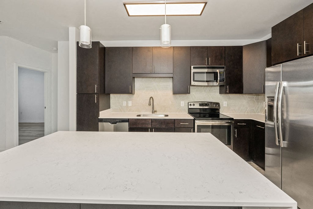a kitchen with a large island and stainless steel appliances