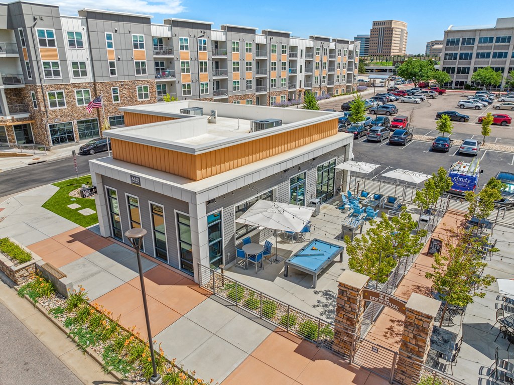 an aerial view of the building with a parking lot in the background