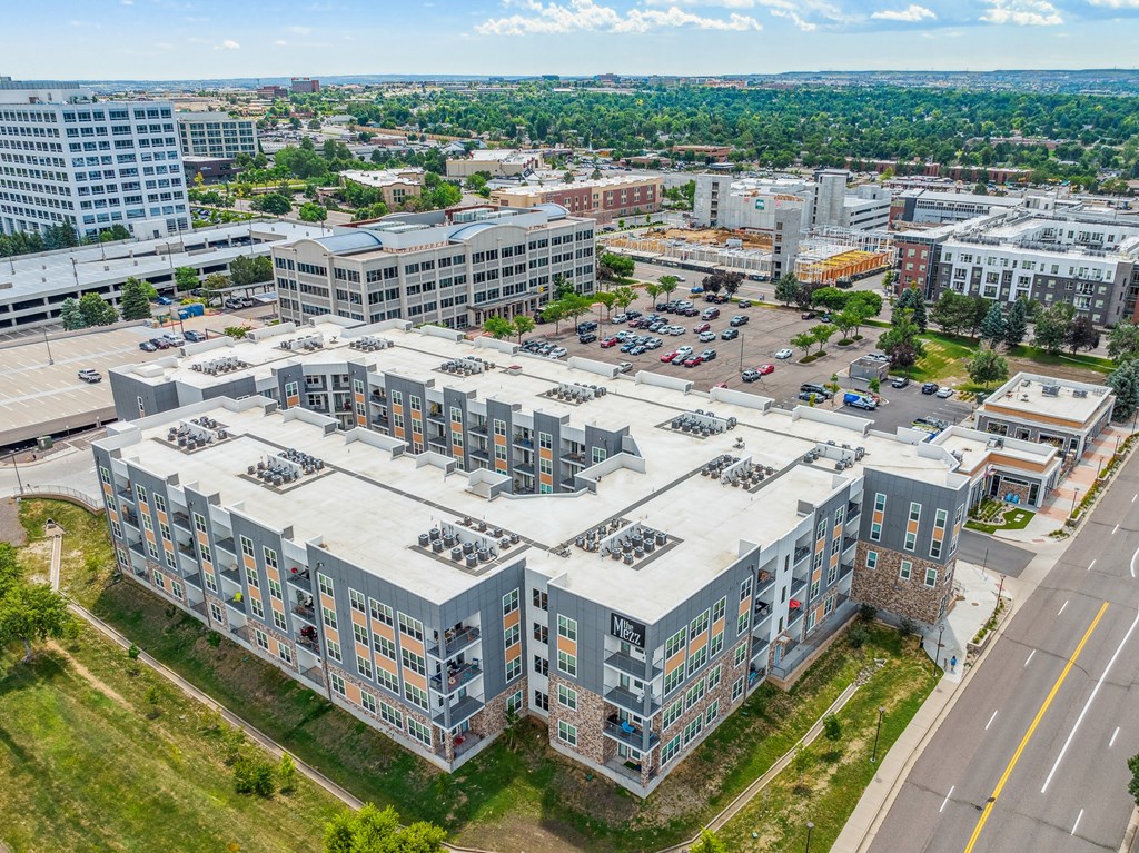 an aerial view of a large building with a parking lot in front of it