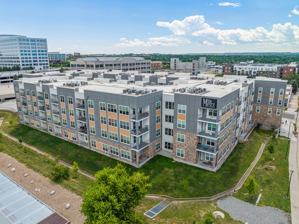 a large building with many windows and a grassy area in front of it