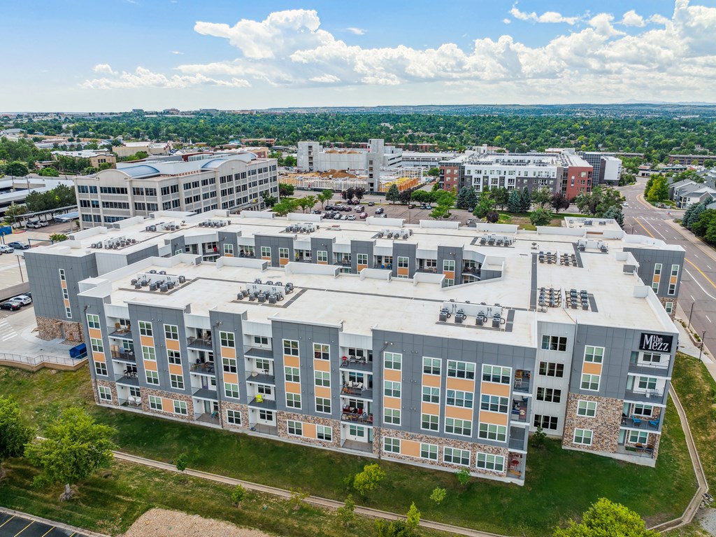 a large building with many windows and a green field in the background